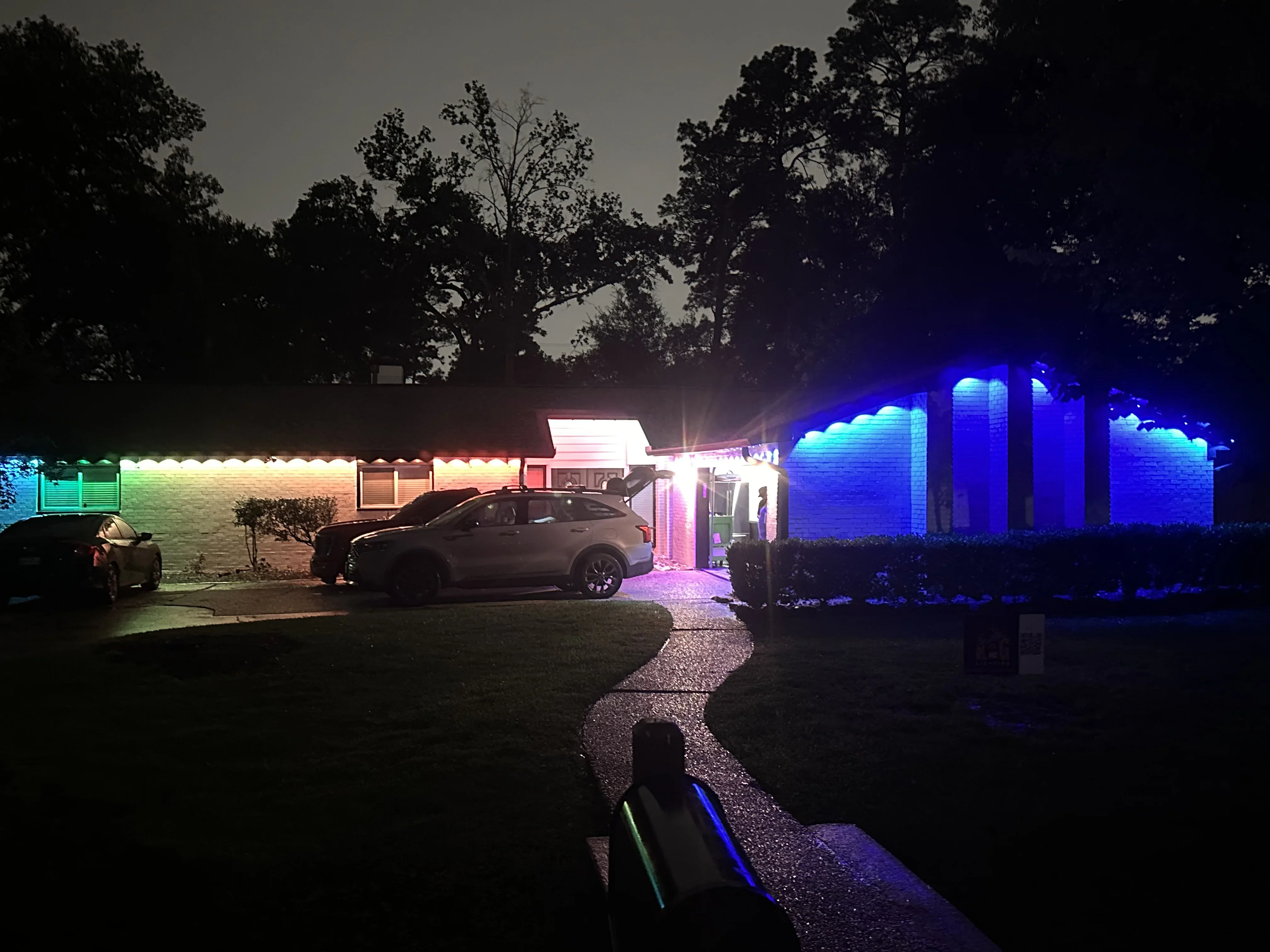 Brick buildings with warm white and blue LED accent lighting, illuminated pathway and driveway