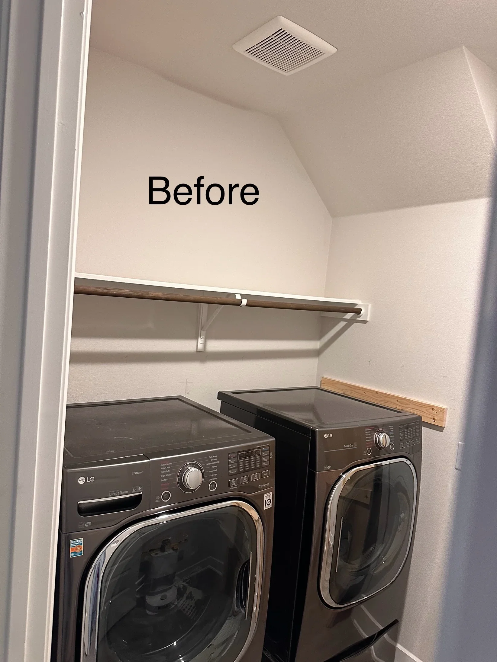 Wooden shelf installed above black LG washer and dryer with ceiling exhaust vent
