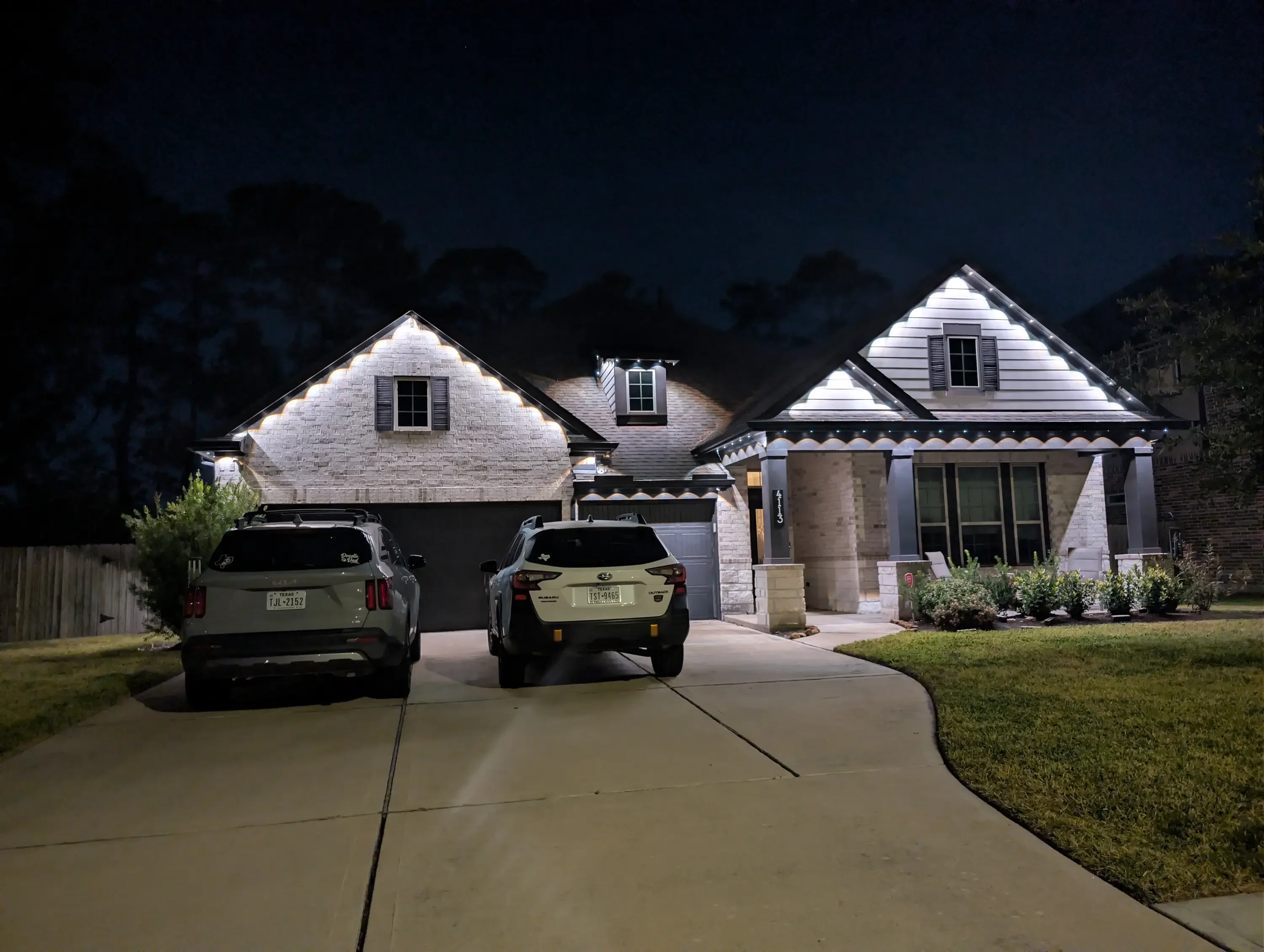 Modern home at night with white LED accent lighting on rooflines and gables
