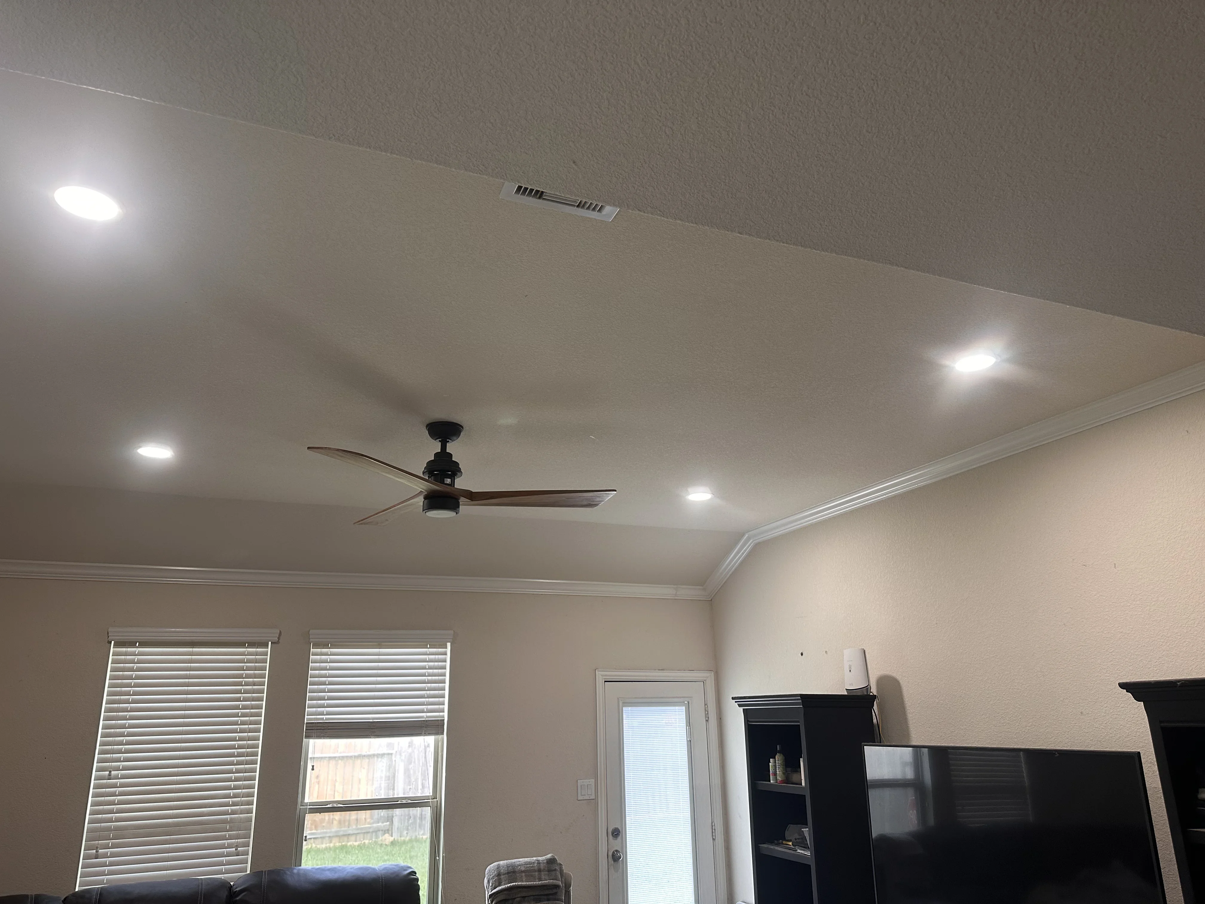 Recessed LED lights and black ceiling fan installed in white drywall ceiling