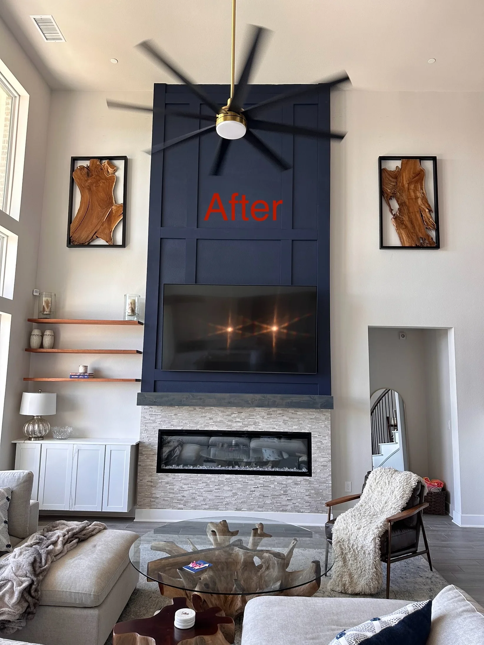 Brass ceiling fan with black blades and LED light above navy fireplace wall with linear electric fireplace insert